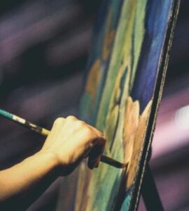 Peintre utilisant un pinceau sur une toile en lien avec la réforme des droits d'auteur Bufiscom