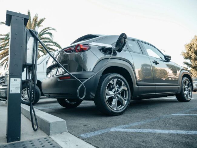 Voiture électrique grise qui recharge à une borne